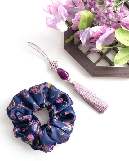 Navy blue hanbok scrunchie with pink floral pattern and decorative hair tie on a white background
